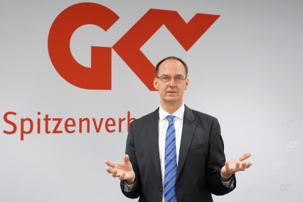 Pressesprecher Florian Lanz vor dem Logo des GKV-SV