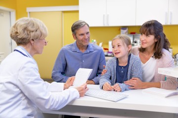 Eine Familie mit Tochter im Gespräch mit einer Ärztin