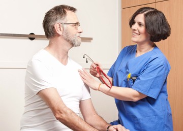 Das Bild zeigt eine Ärztin mit einem Patienten.